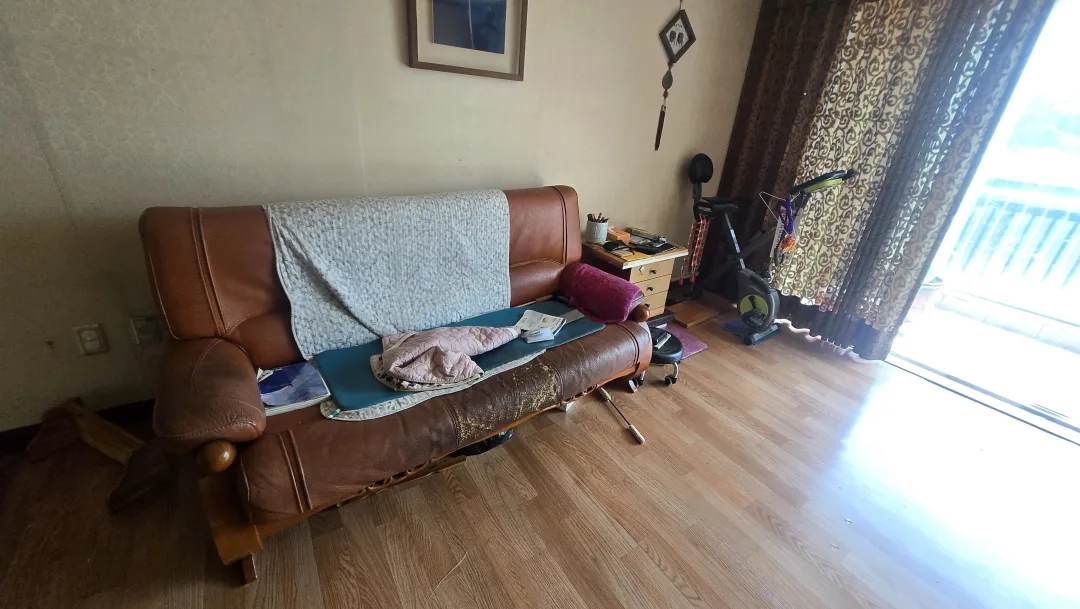 유품정리 전(Before) - 낡은 소파와 운동기구가 있던 거실
